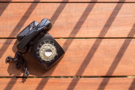 vintage black telephone on wooden background