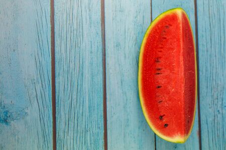 Top view watermelon slice one piece on a blue wood backgroundの写真素材