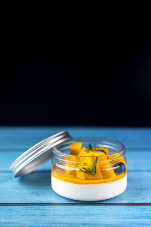 Dessert Homemade panna cotta with mango on a blue wood backgroundの写真素材