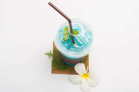 Italian blue soda and Plumeria flower on white backgroundの写真素材