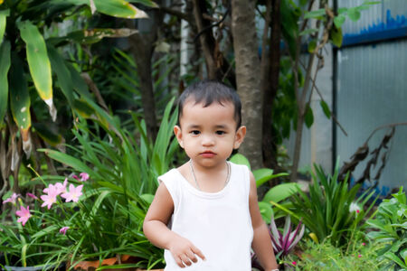 Asian little boy sits on a in a park,Asian little boyの写真素材
