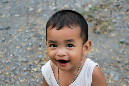 Asian little boy sits on a in a park,Asian little boyの写真素材