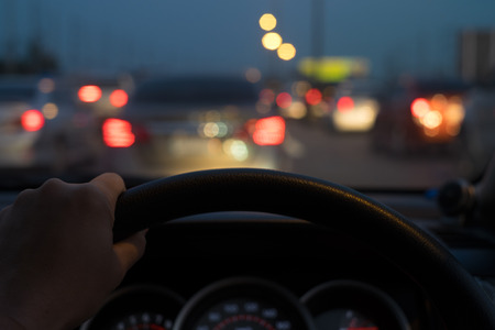 hand on steering wheel with blurred street backgroundの写真素材