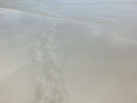 The sea water is clear, can see the sand and there is a shadow from the sun.の写真素材