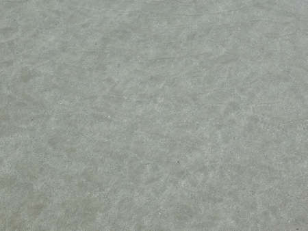 The sea water is clear, can see the sand and there is a shadow from the sun.の写真素材