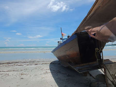 Blue and green local fishing boats moored on the shorelineの写真素材