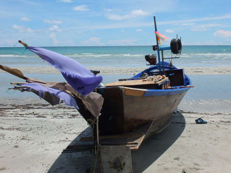 Blue and green local fishing boats moored on the shorelineの写真素材