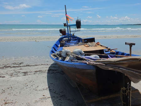 Blue and green local fishing boats moored on the shorelineの写真素材