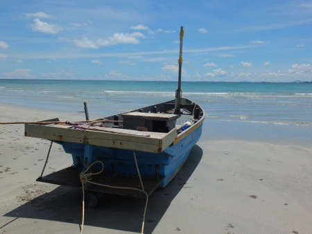 Blue and green local fishing boats moored on the shorelineの写真素材