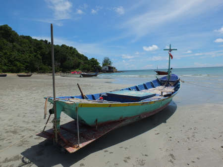 Blue and green local fishing boats moored on the shorelineの写真素材