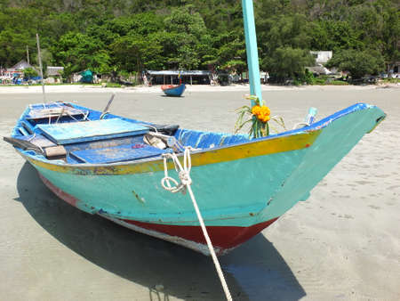 Blue and green local fishing boats moored on the shorelineの写真素材