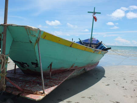 Blue and green local fishing boats moored on the shorelineの写真素材