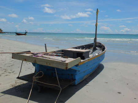 Blue and green local fishing boats moored on the shorelineの写真素材