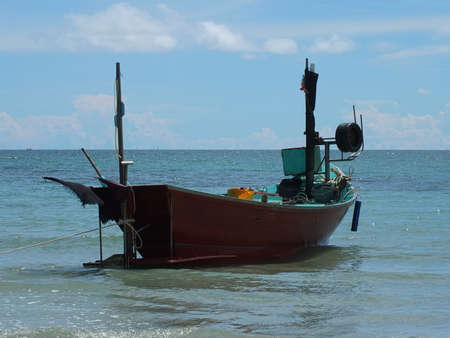 Blue and green local fishing boats moored on the shorelineの写真素材