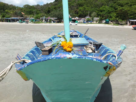 Blue and green local fishing boats moored on the shorelineの写真素材