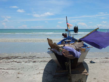Blue and green local fishing boats moored on the shorelineの写真素材