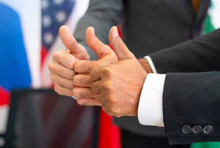 Three of thumbs up from business man or politician during international conferenceの写真素材