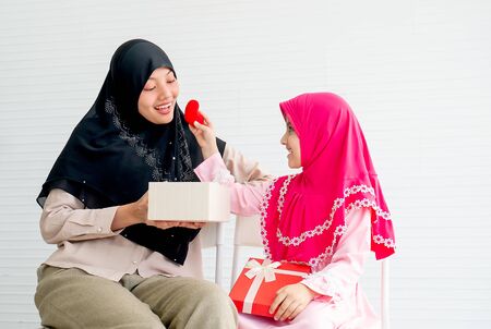 Muslim little girl give heart symbol to her mother with concept love and relationship in family.の写真素材