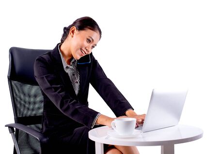 Portrait isolated Southeast Asian business woman wears dark gray suit is working in office by call to someone on  white background.の写真素材