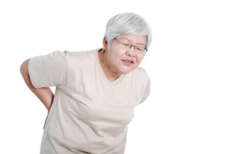 One Asian elderly woman express action of back pain and isolate on white background.の写真素材