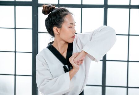 Close up shot of young taekwondo show different postures in front of white pattern background.の写真素材