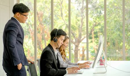 Chief of operator team stand behind his team and support of their working during day time.