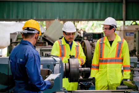 Two yellow uniform technician man with blue uniform work together as team to maintenance and check...