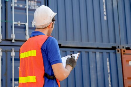 Back of technician who check the quality of cargo containers in shipping area.
