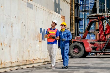 Technician and engineer work together for checking quality and product in cargo container shipping area.の写真素材