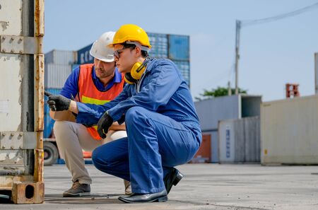 Technician and engineer work together for checking quality and product in cargo container shipping area.の写真素材