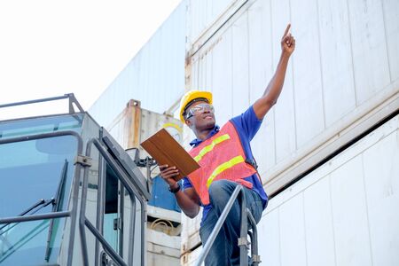 African technician worker stand on big truck and point to some direction with concept go to the way...
