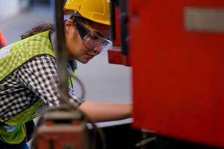 Beautiful Asian worker or technician woman fix the problem of machine in factory.の写真素材
