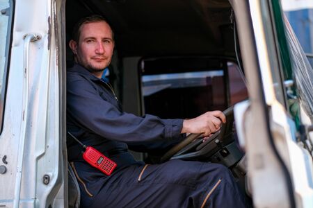 Technician or worker sit on driver seat and look to the camera in cargo container shipping area.の写真素材