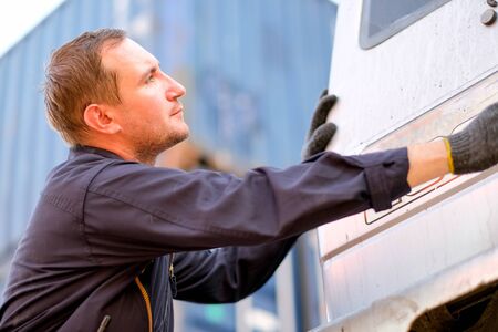 Technician or worker in cargo shipping check or maintenance truck in container area.の写真素材