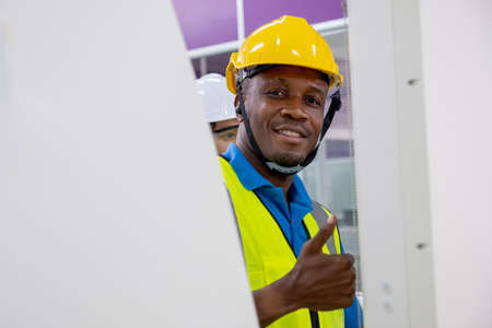 African American factory worker man smile and show thumbs up to camera through channel of the...