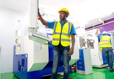 African American factory worker work with the machine in workplace area. Concept of good management...