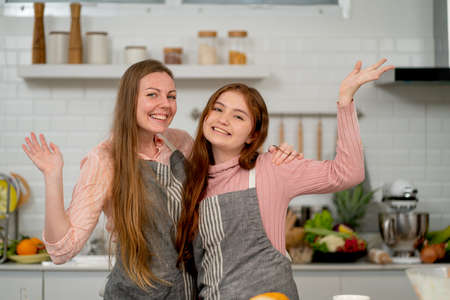 Caucasian mother and daughter show action of happy and enjoy together in their home kitchen during cooking and have good time activities of family.の写真素材