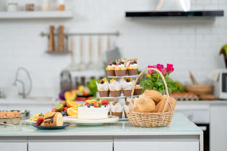 Bread and other bakery in basket are put on table in modern kitchen with concept of clean and diversity and different style of accessories for cooking at home.の写真素材