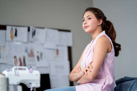 Young professional designer woman or tailor stand with confident look forward and stay in her workplace room with concept of small business and modern lifestyle.の写真素材