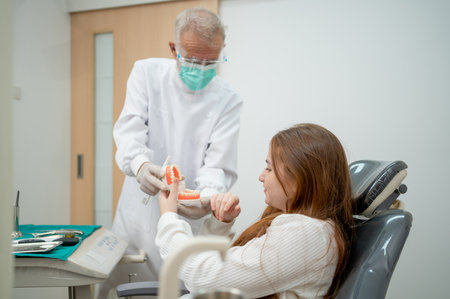 Caucasian girl look happy and enjoy with senior dentist who try to entertain and make his customer feel funの写真素材