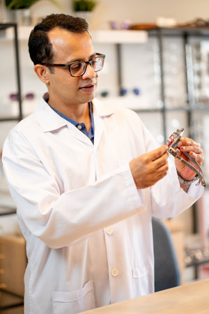 ophthalmologist or optical staff hold special glasses for testing and check the function before use in the shop.の写真素材