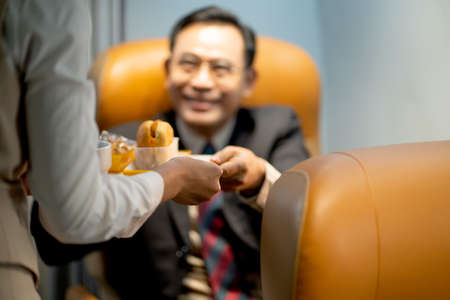 Main focus on woman hands, business man receive dessert and cake from air hostess or cabin crew...