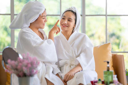 One of Asian beautiful girl with spa robe tease or make kidding with her friend after spa massage and they look relax and happy.の写真素材