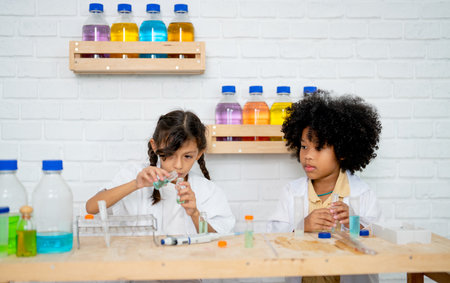 Two little girls practice in science class with different laboratory equipment with concentrate in their work.の写真素材
