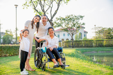 Asian family stay in garden in area of their home village with soft light in evening and they look at camera with smiling.の写真素材