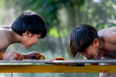 Close up Asian boys enjoy and fun together for playing blow the rubber look like competition with traditional culture and they look happy with smiling.の写真素材