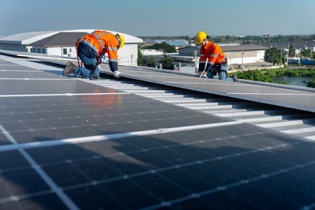 Lower view with panel as foreground, two Caucasian technician workers work with install the solar...