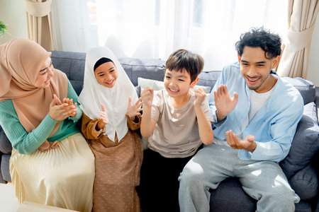 Asian muslim family compose of mother, father, daughter and son express happy for some success of the activity in their house.の写真素材