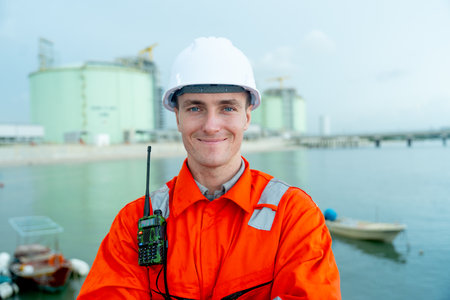 Portrait of petrochemical worker or technician stand with arm-crossed with smiling in front of factory tank.の写真素材