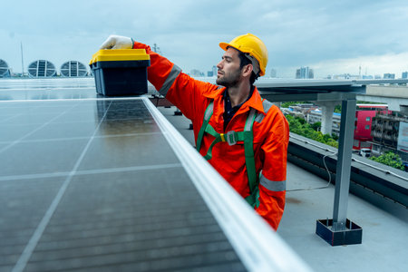 Engineer or technician worker put toolbox on solar cell panel during check or maintenance on rooftop...